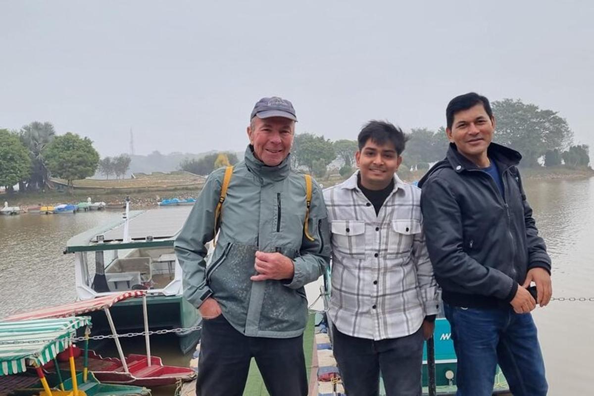 a group of three men standing next to a river