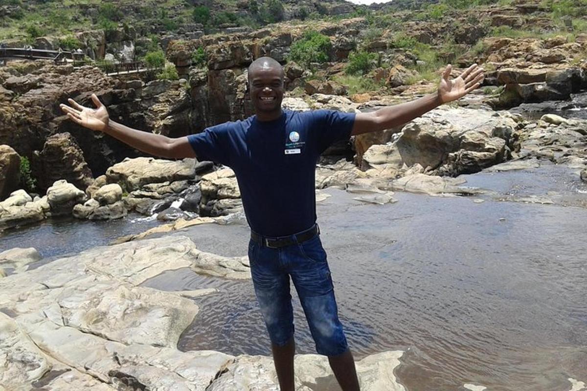a man standing on some rocks with his arms outstretched