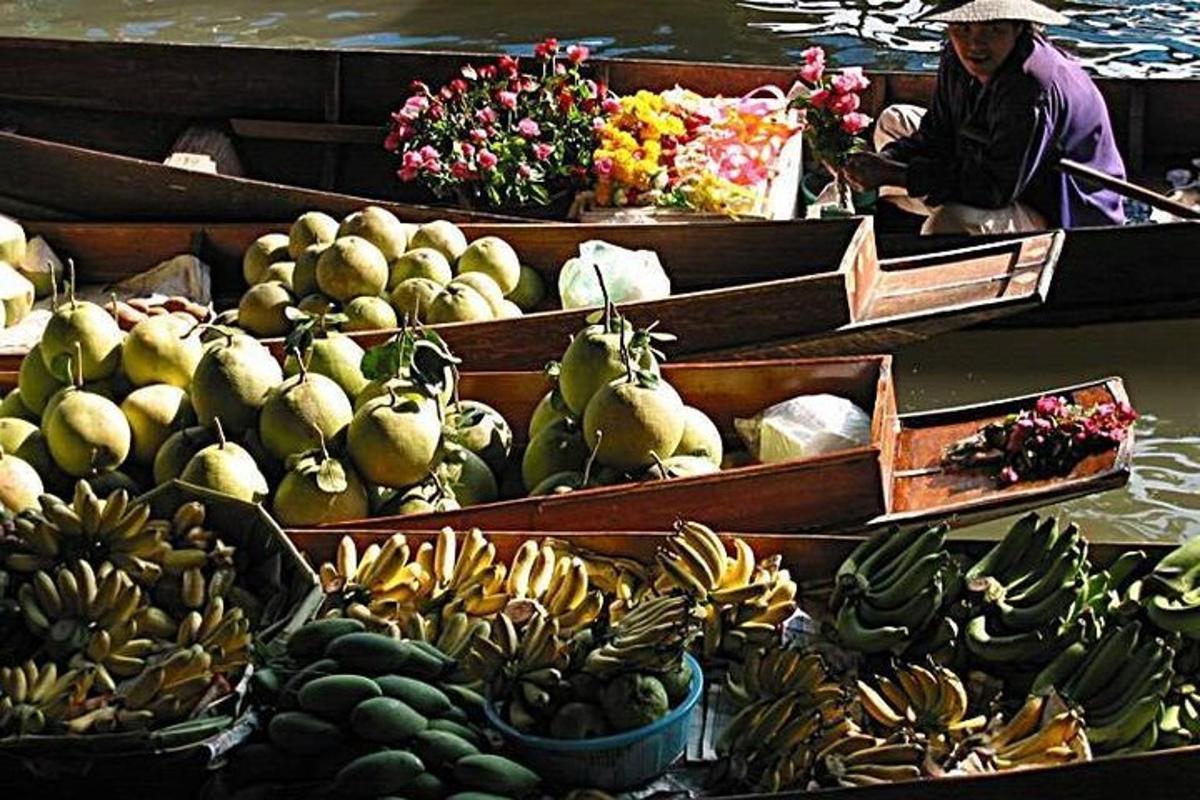 a woman in a boat filled with fruits and vegetables