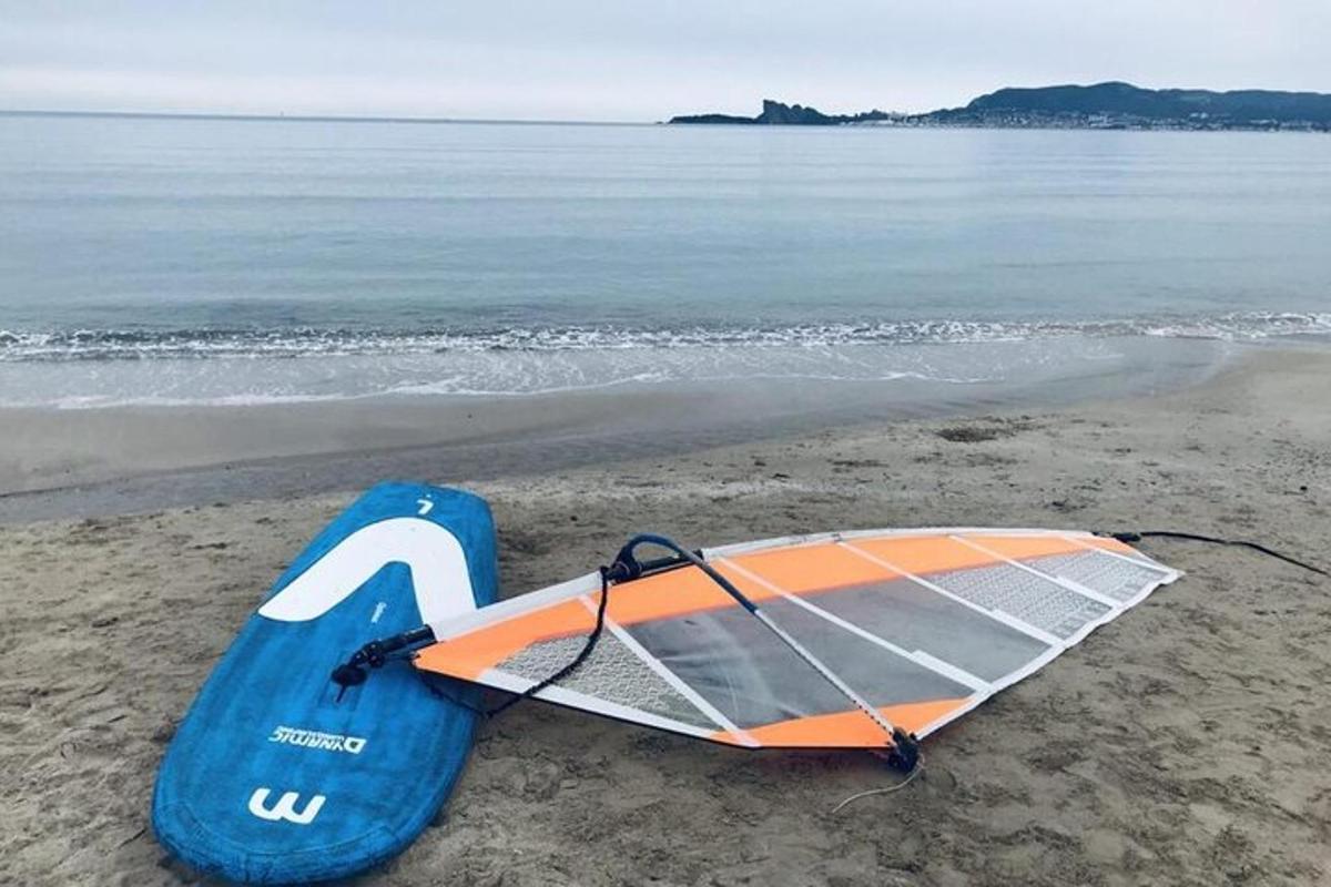 papan selancar yang diletakkan di atas pasir di pantai