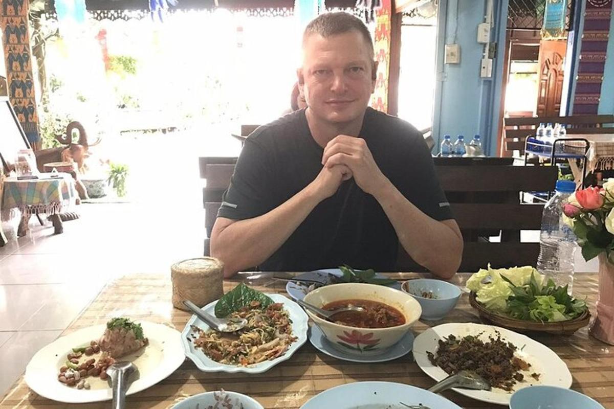 un hombre sentado en una mesa con platos de comida