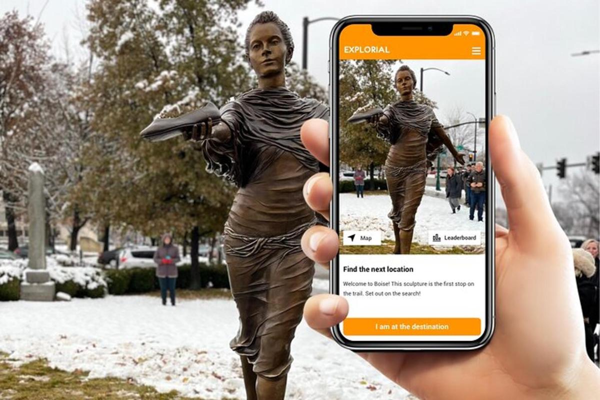 una persona che tiene in mano un cellulare per scattare una foto di una statua