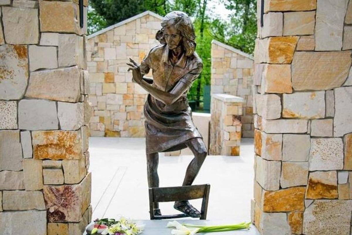 una statua di una donna seduta su una sedia