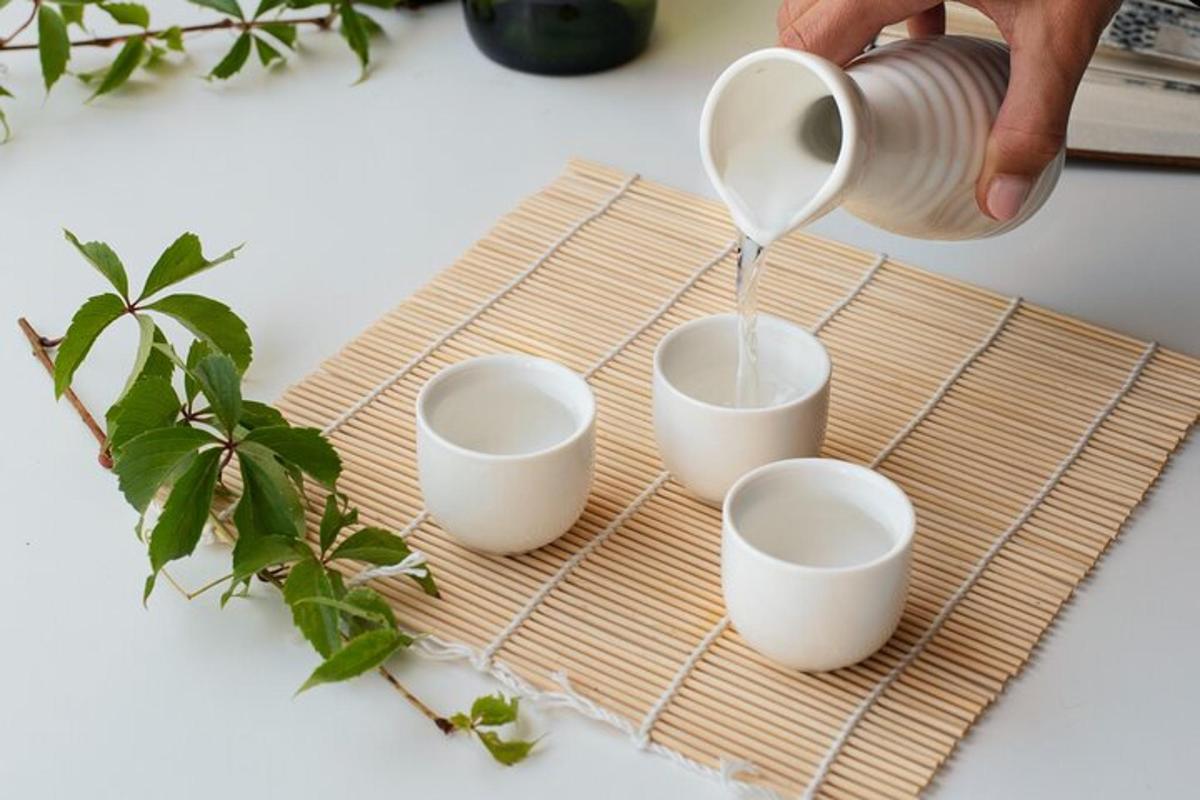 una persona che versa il caffè in tre tazze su un tagliere di bambù