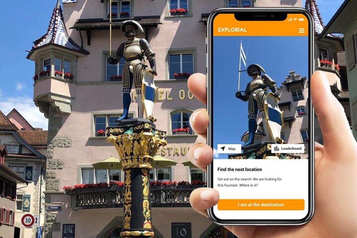 osoba držící mobilní telefon před sochou