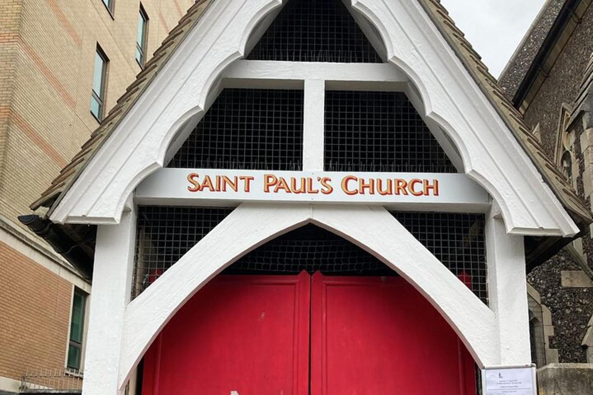 a red door of a church with a sign above it