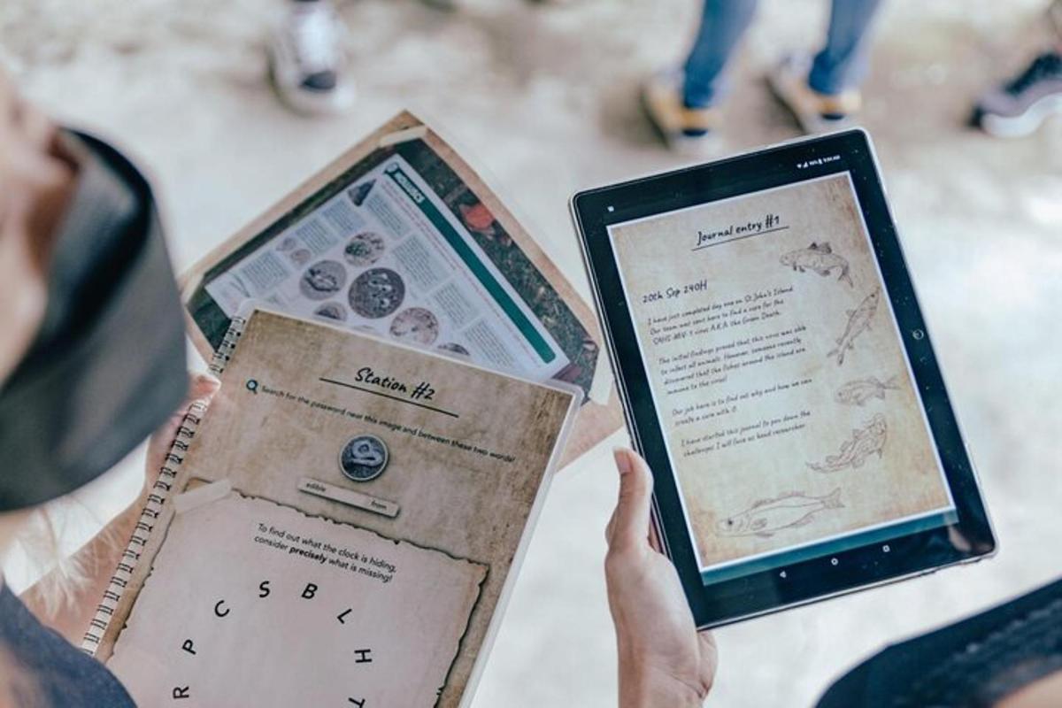oseba, ki drži tablični računalnik in knjigo