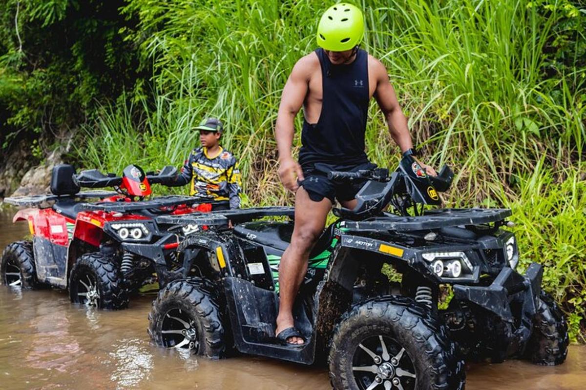 một người đàn ông đứng trên một chiếc xe địa hình dưới nước