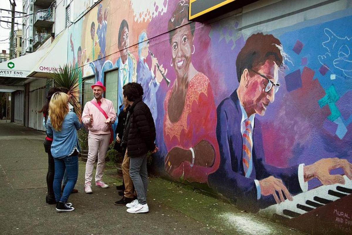 sekelompok orang berdiri di depan mural