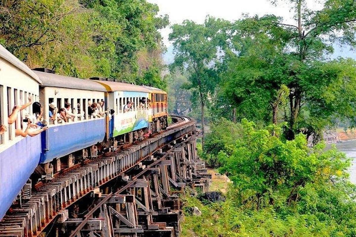a train on a bridge with people riding on it