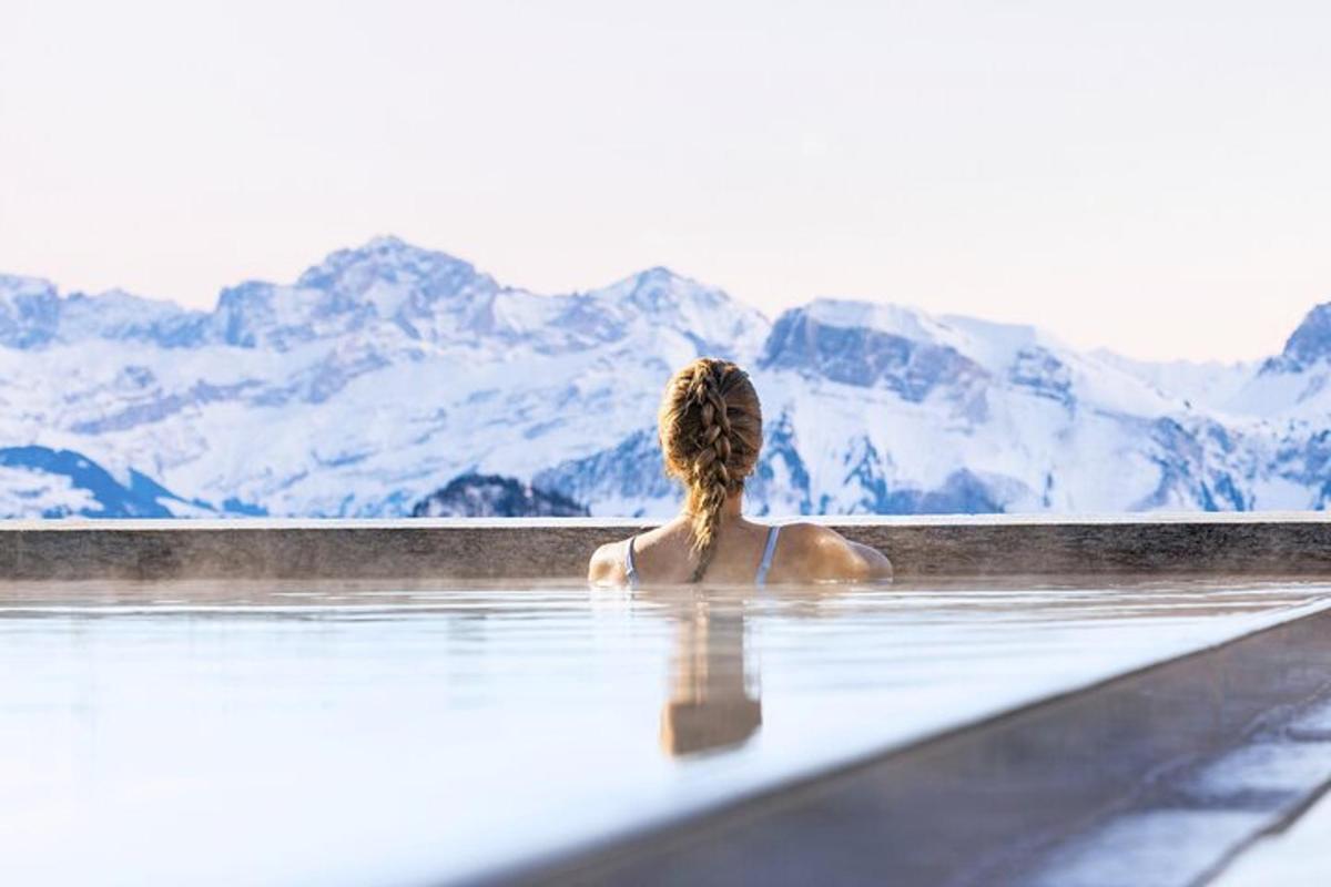 una donna seduta in una vasca da bagno che guarda le montagne
