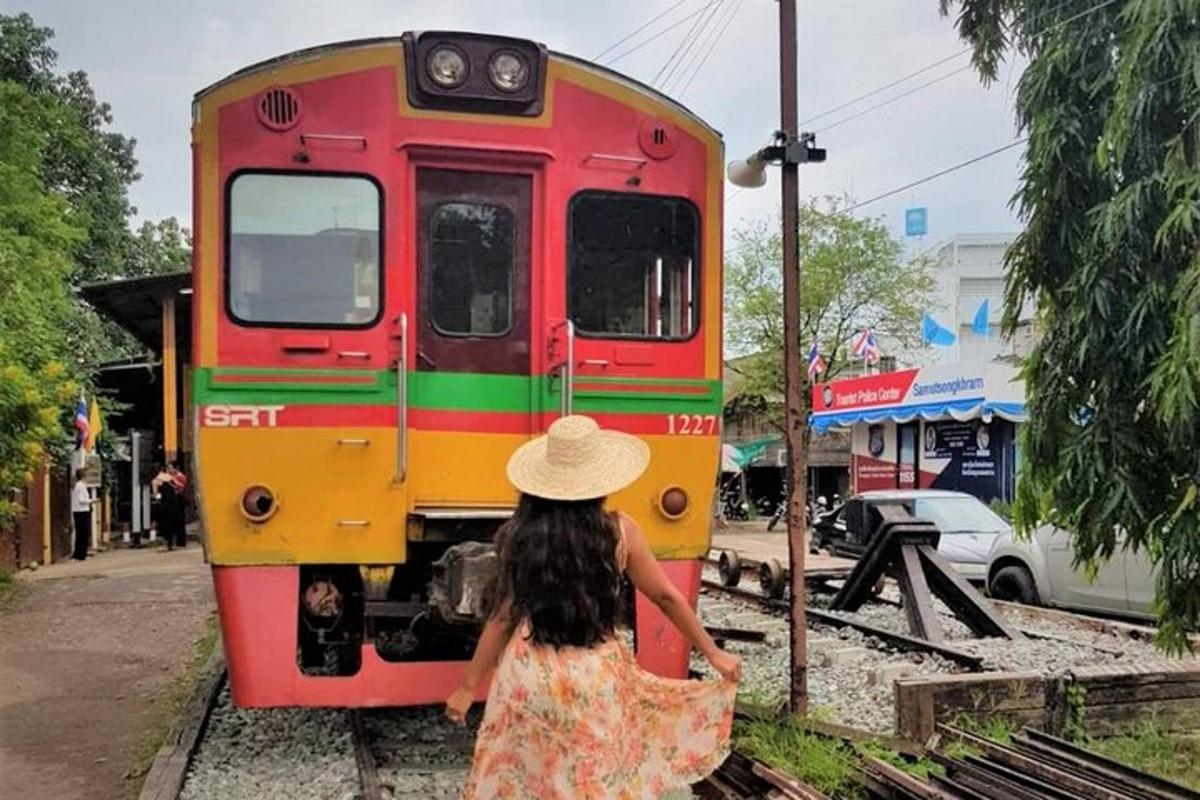 o femeie mergând spre un tren roșu și galben