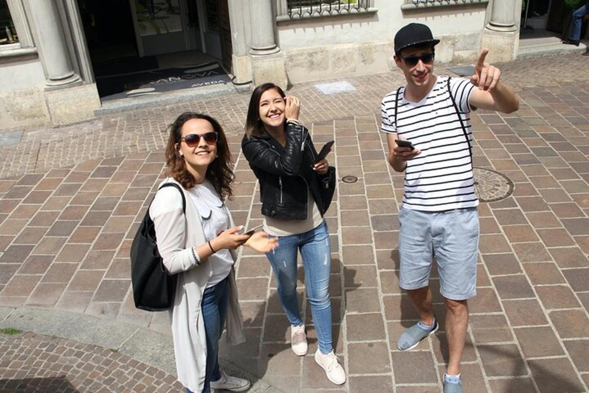 Dos mujeres y un hombre posando para una foto con sus teléfonos celulares.