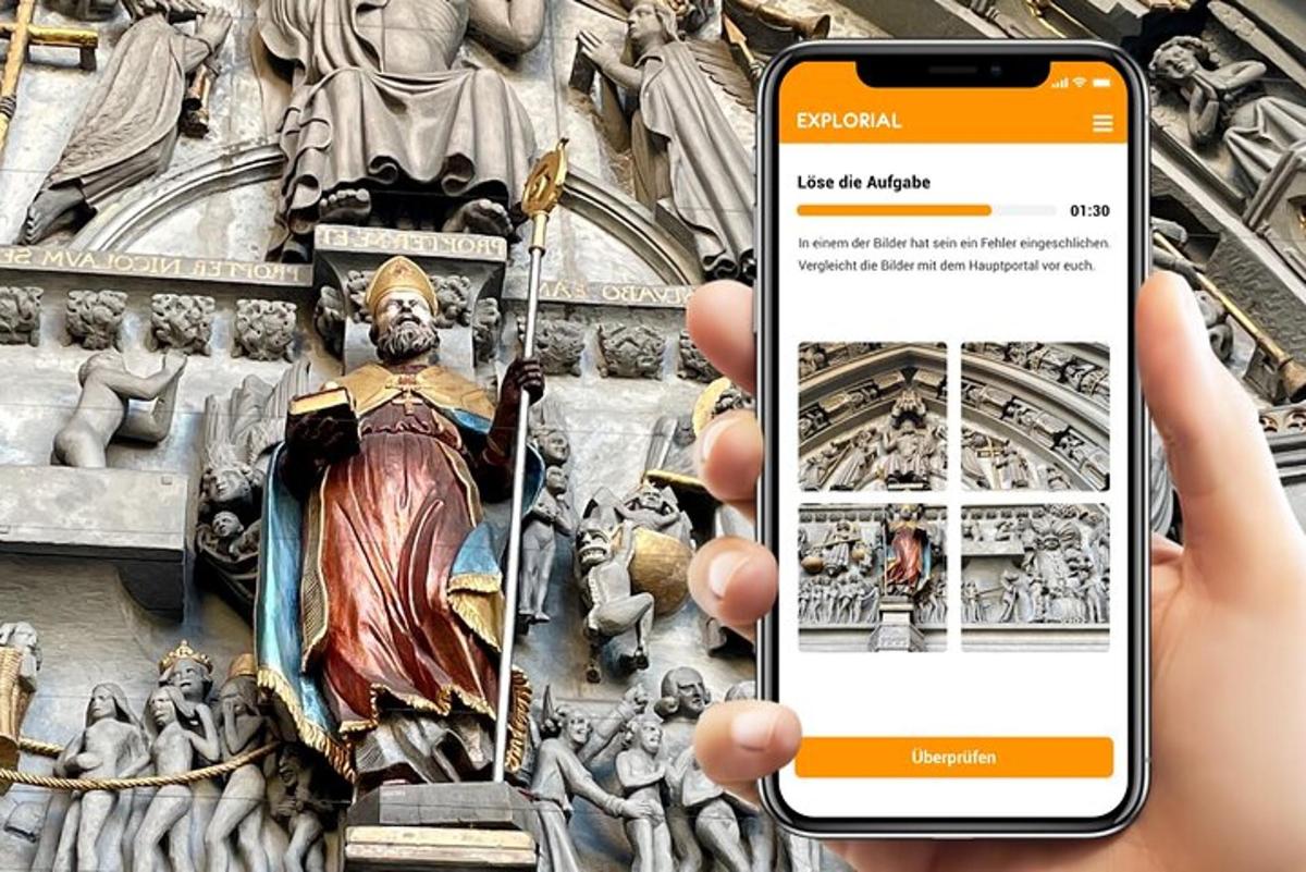una persona sosteniendo un teléfono celular frente a una estatua