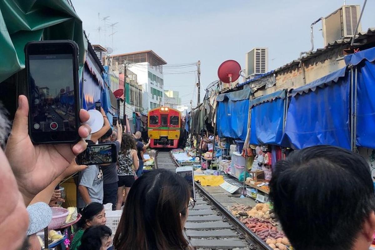 una persona fent una foto d'un tren en un mercat
