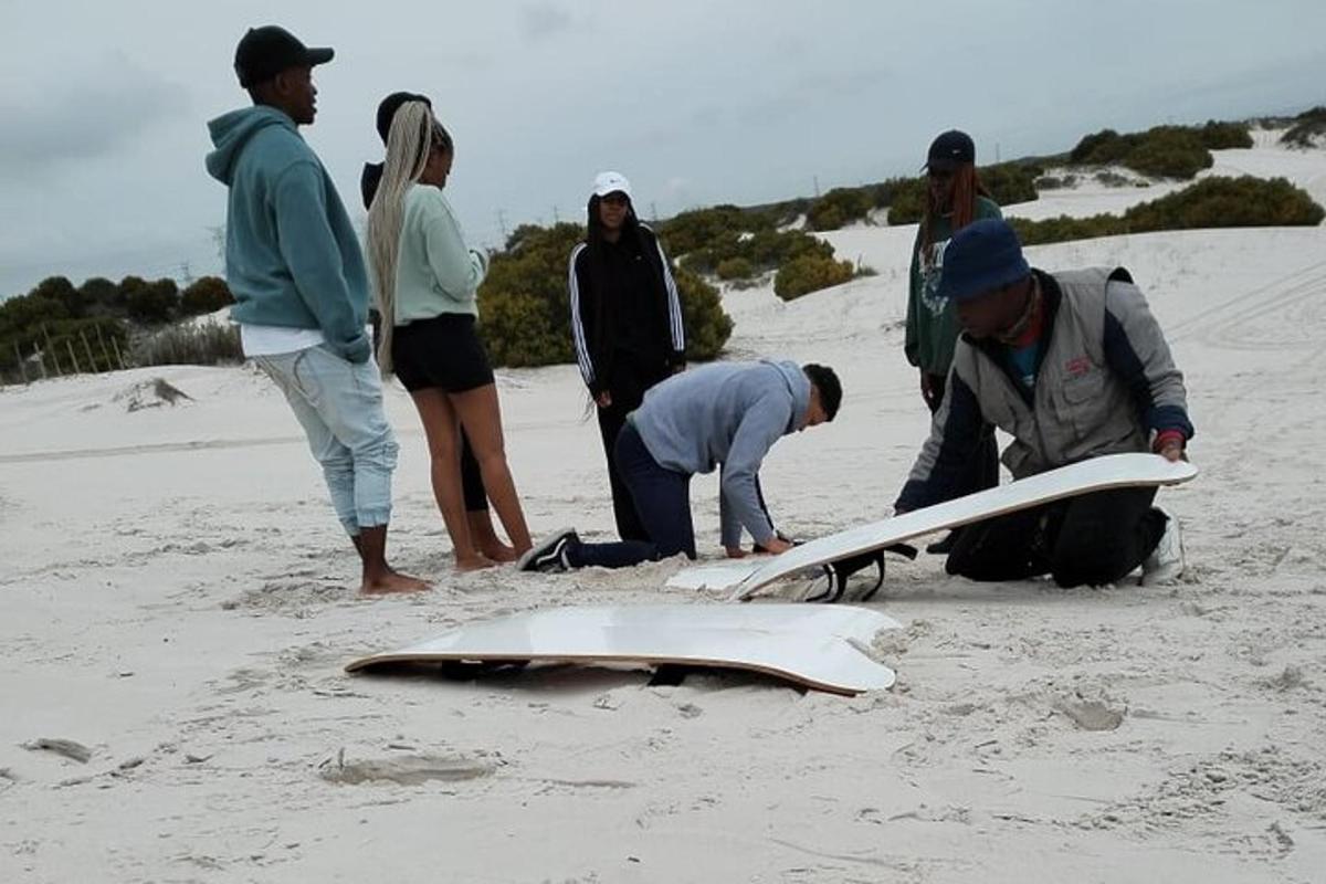 eine Gruppe von Menschen mit einem Surfbrett am Strand