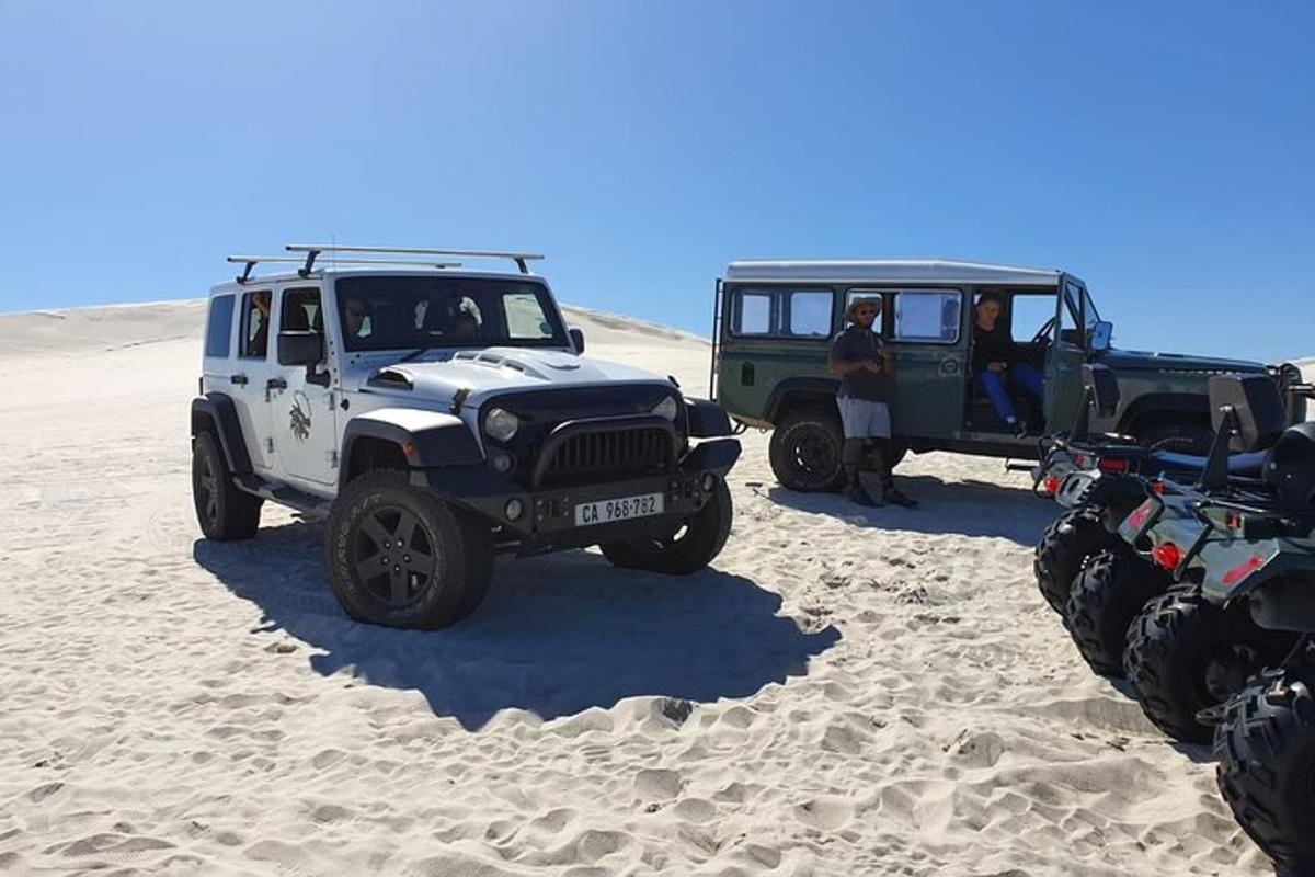 eine Gruppe von Jeeps, die im Sand geparkt sind