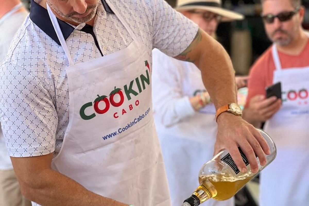 човек у белој кецељи који држи флашу пива