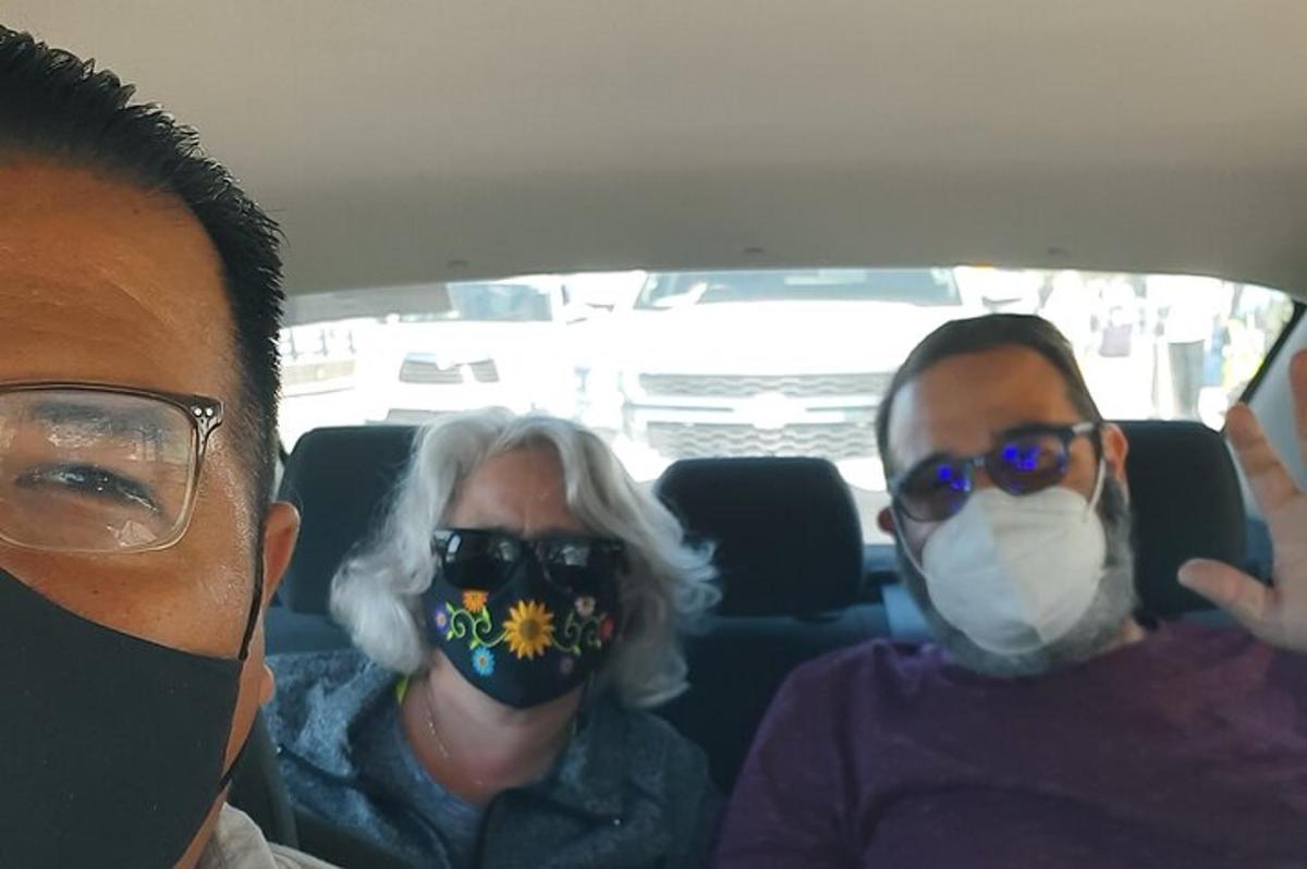 dues persones assegudes en un cotxe amb mascaretes a la cara