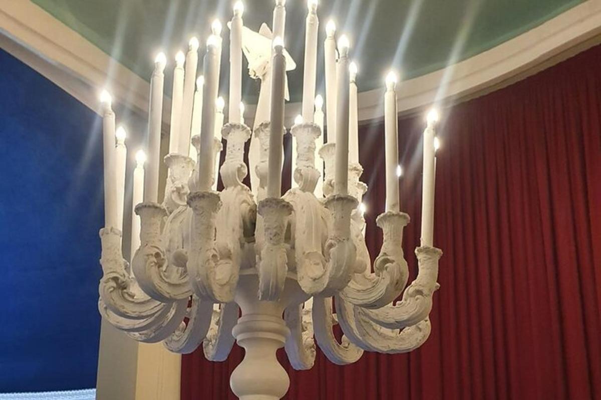um lustre com muitas velas brancas em uma sala