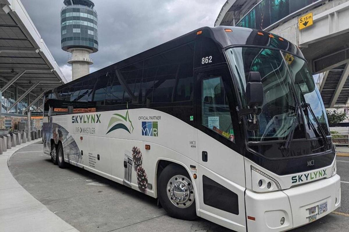 Velký bílý autobus zaparkovaný vedle budovy