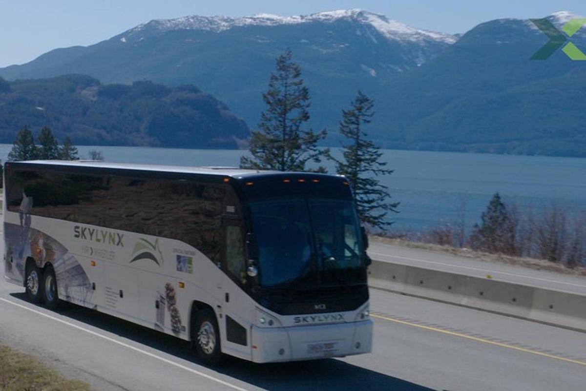 um ônibus dirigindo por uma estrada próxima a um lago