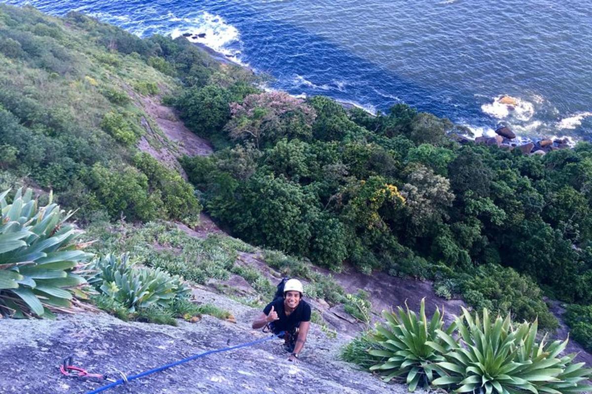 um homem em pé no topo de uma colina perto do oceano