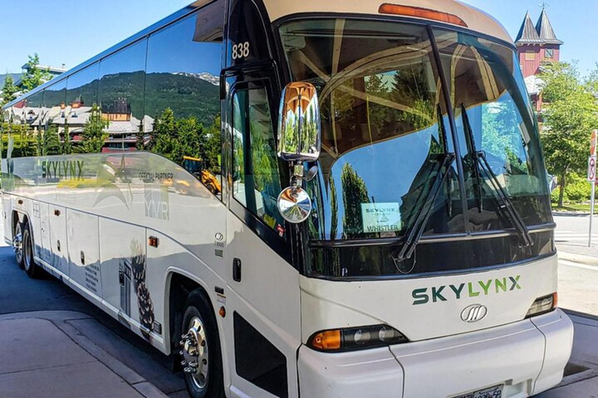 um grande ônibus branco estacionado em um estacionamento