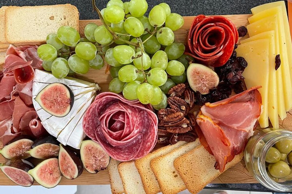 ein Teller mit Essen mit Trauben, Fleisch und Käse