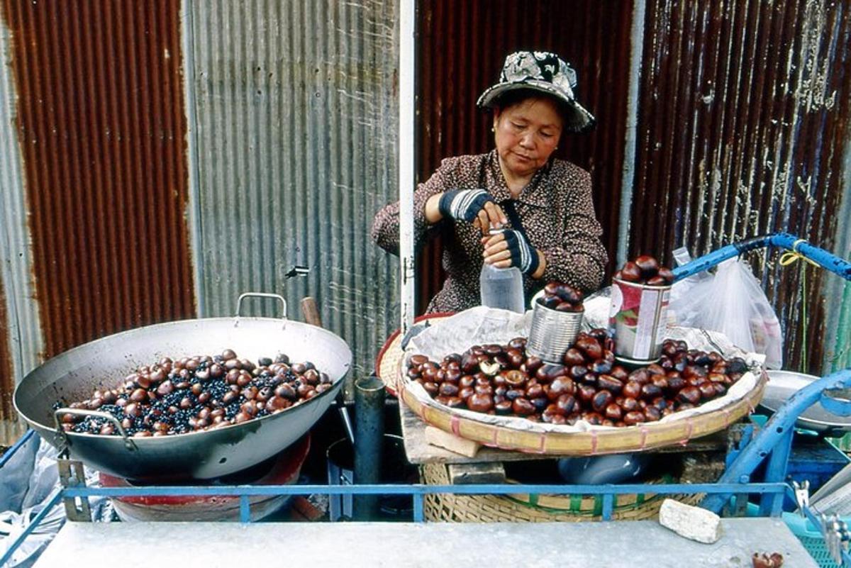 a woman is standing next to a bowl of olives