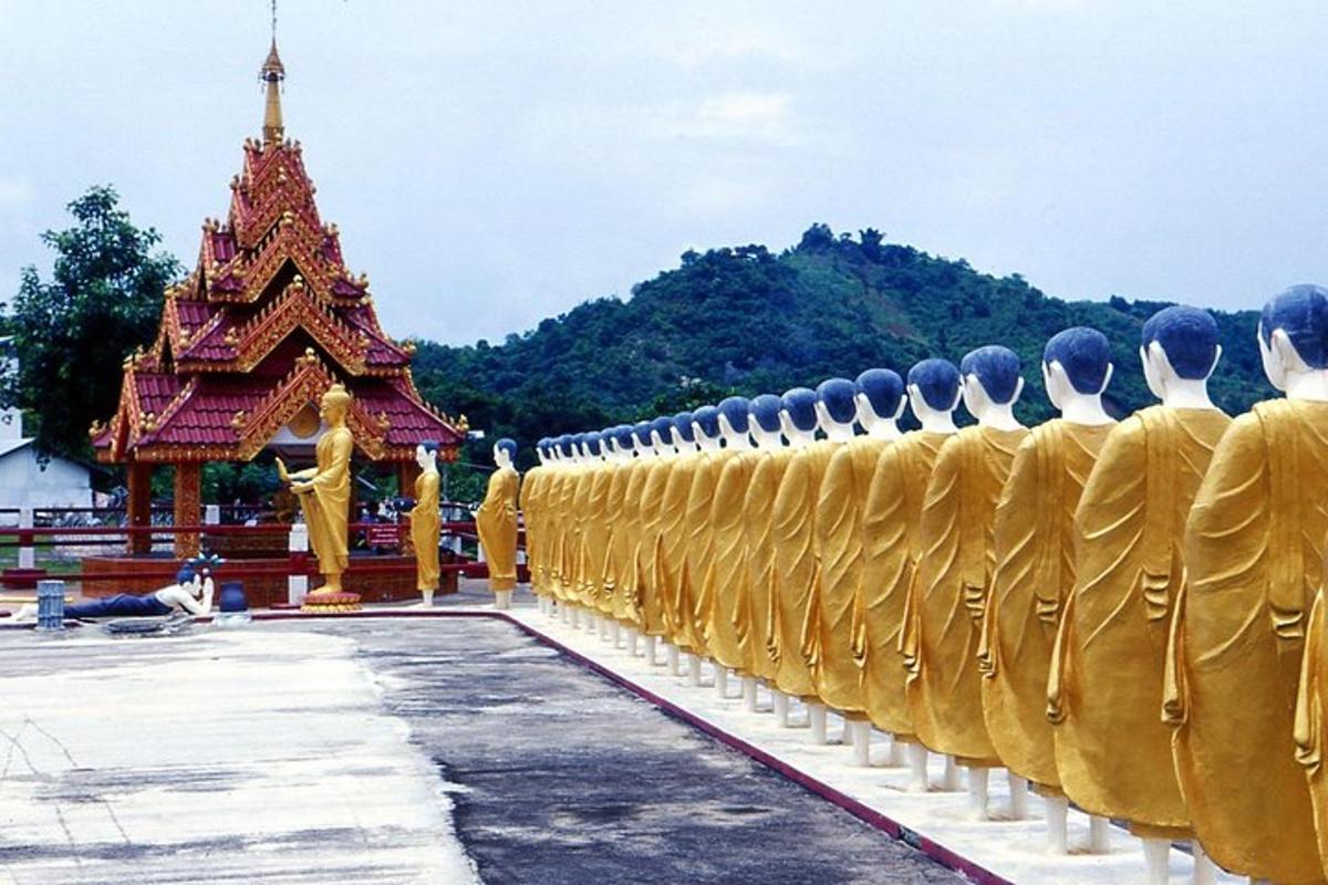 a group of men in gold uniforms in front of a temple