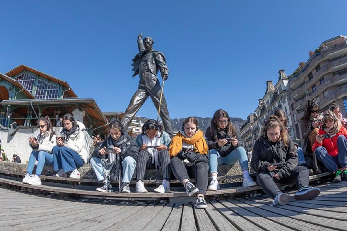 hópur fólks situr fyrir framan styttu
