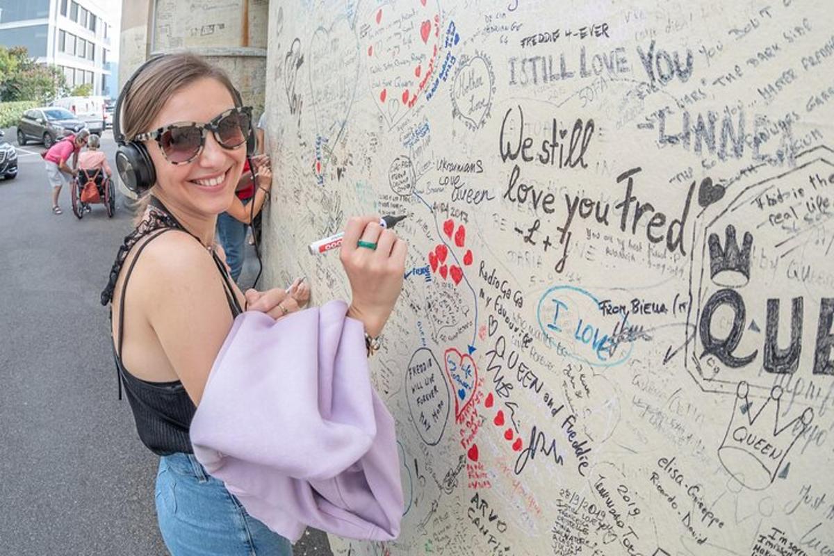 bir kadın grafiti bulunan bir duvarın yanında duruyor
