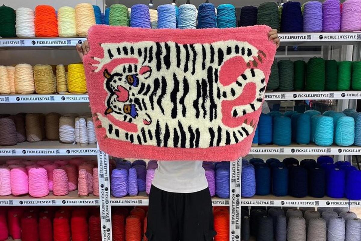 seseorang sedang memegang karpet bergambar harimau di atasnya