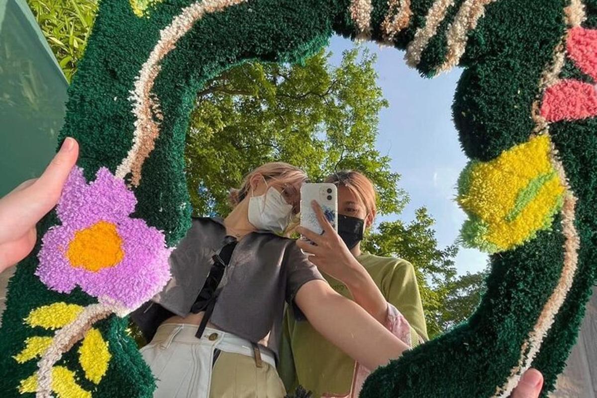 due persone che scattano una foto a una persona che indossa una maschera