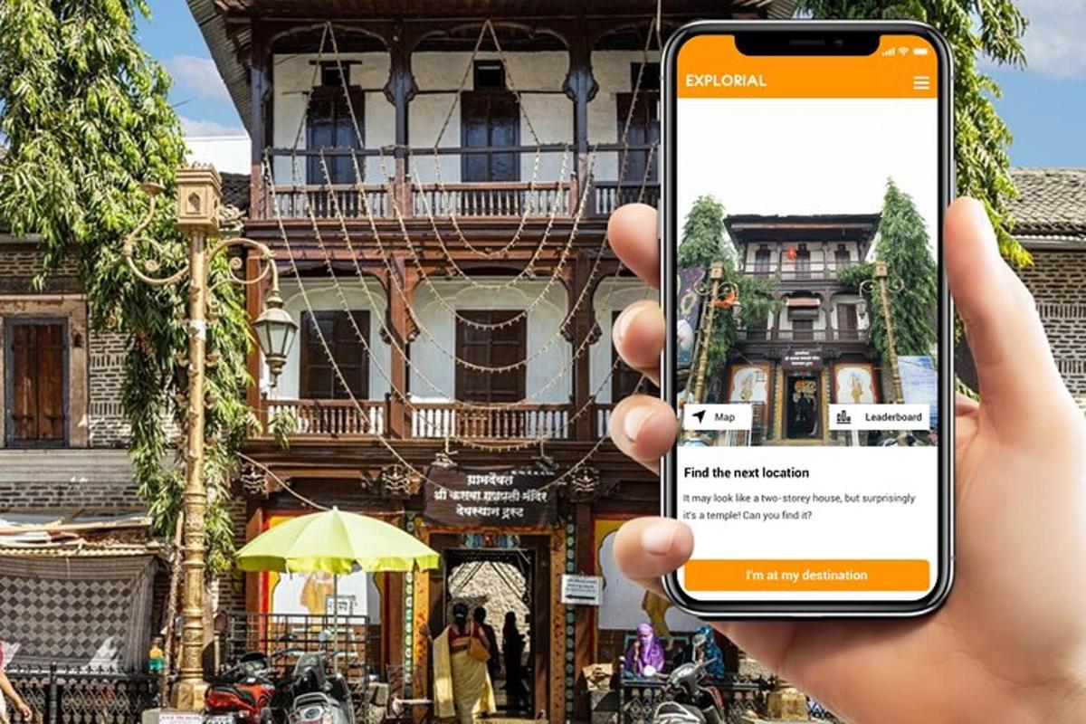 en person som holder en mobiltelefon foran en bygning