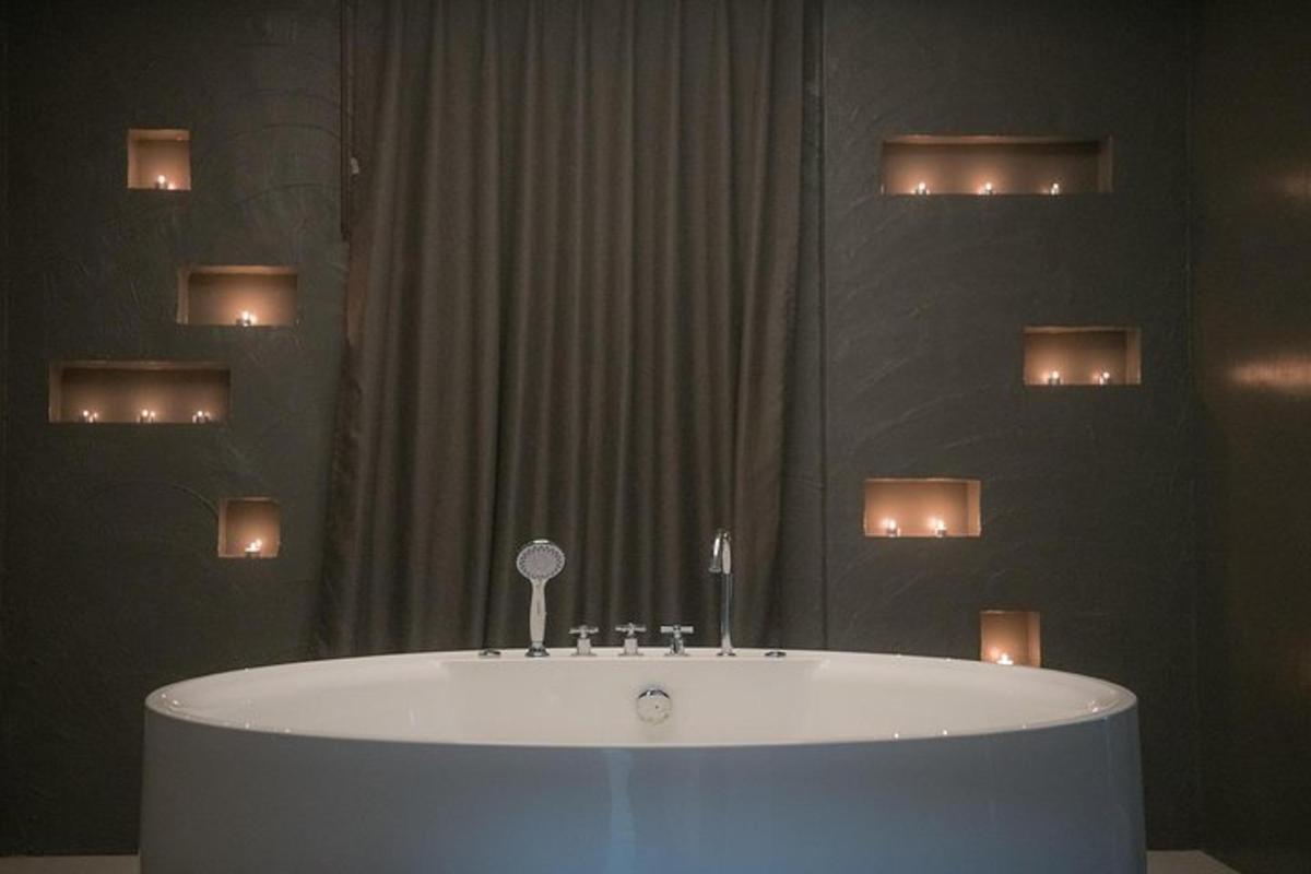 una vasca da bagno in un bagno con luci sul muro