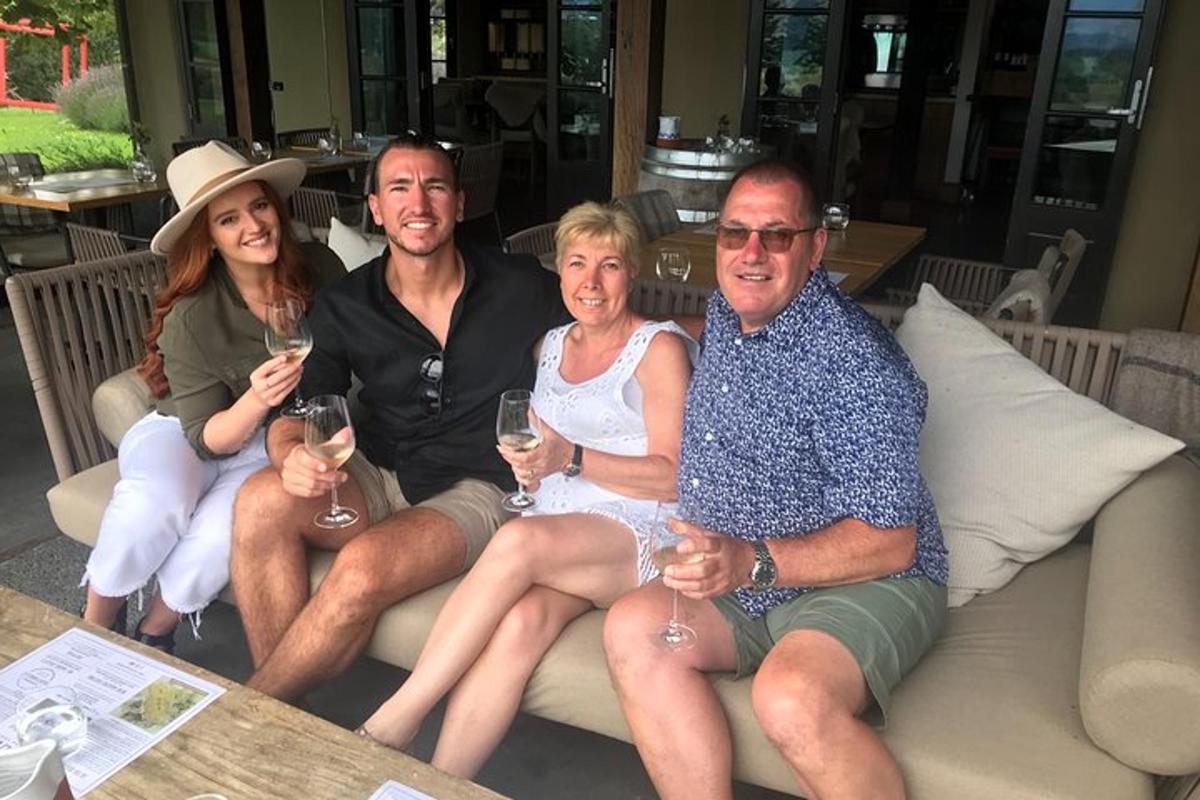 a group of people sitting on a couch with wine glasses