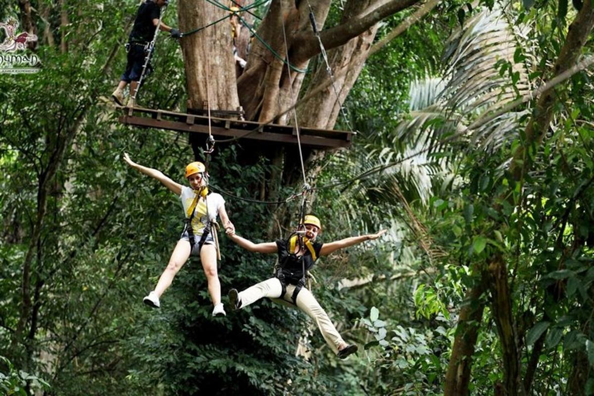 duas pessoas estão fazendo tirolesa na selva