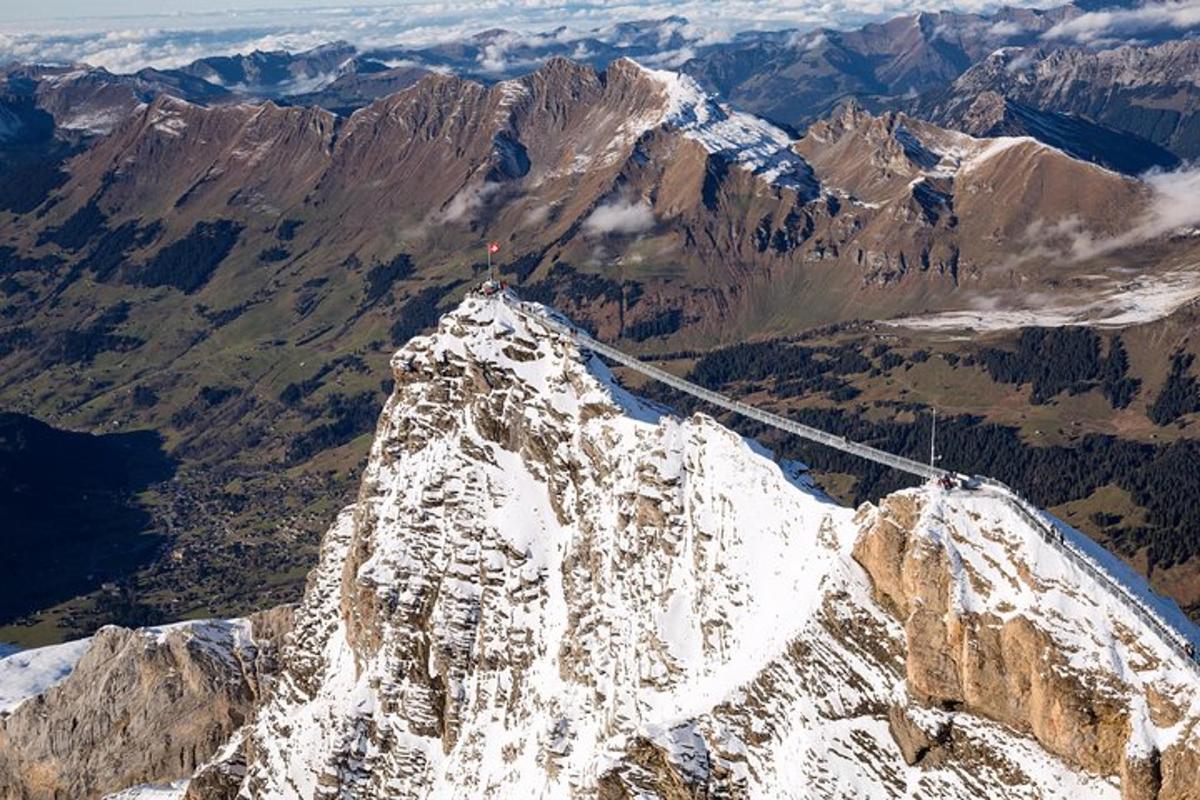 a rope bridge on top of a snow covered mountain