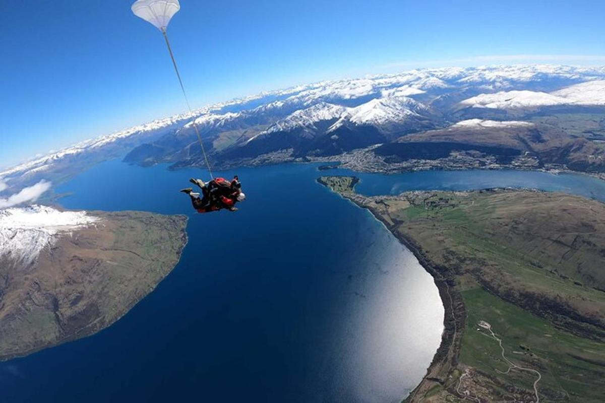 a person hanging from a parachute over a lake