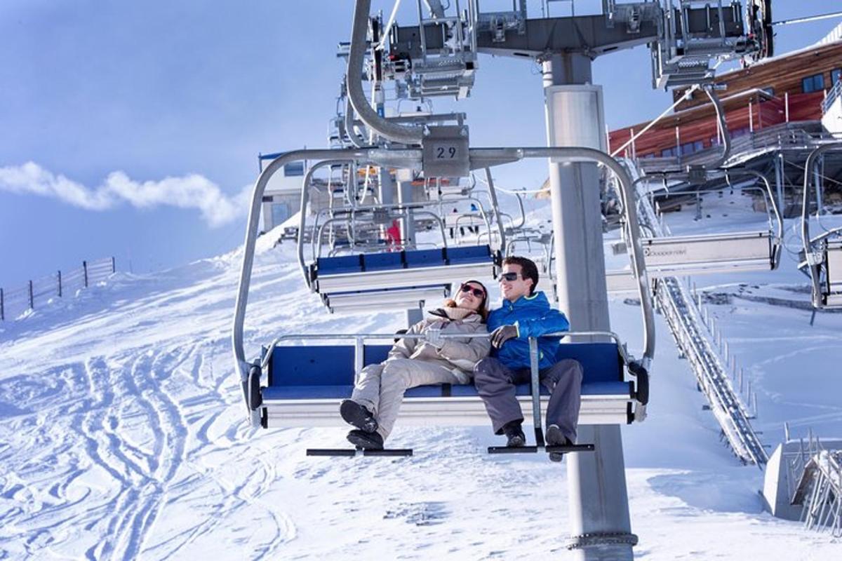 a man and a woman sitting on a ski lift