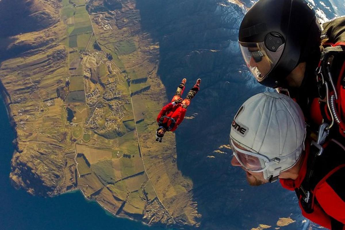 two people are looking up at a person in an airplane