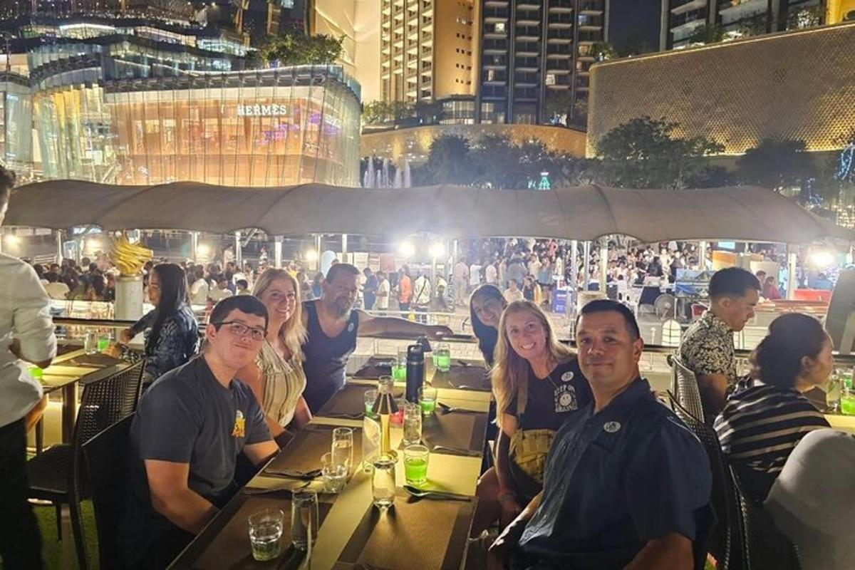 skupina lidí sedících v noci u stolů v restauraci