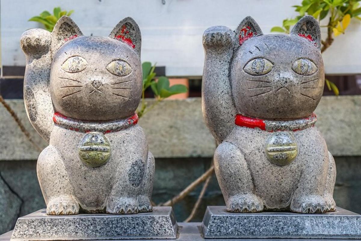 two statues of cats sitting next to each other