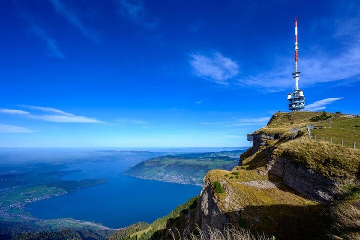 un faro in cima a una montagna con uno specchio d'acqua