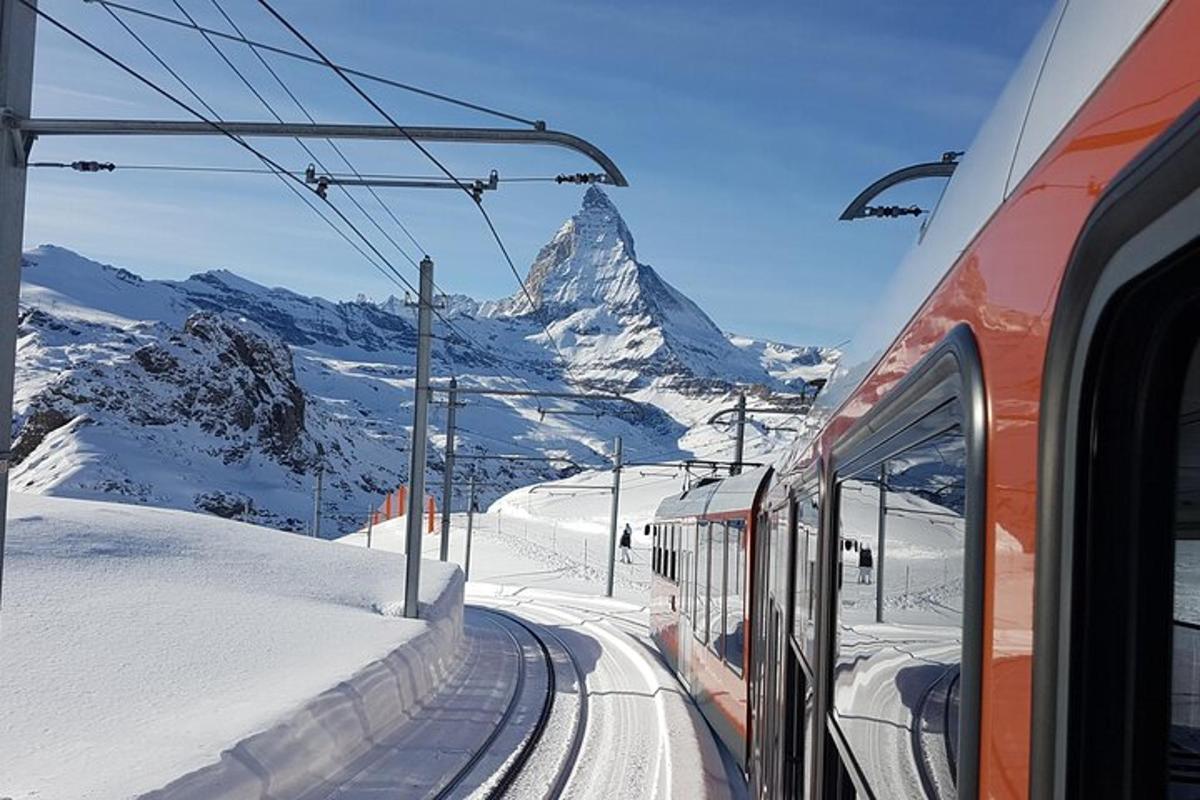 a train on the tracks in front of a mountain