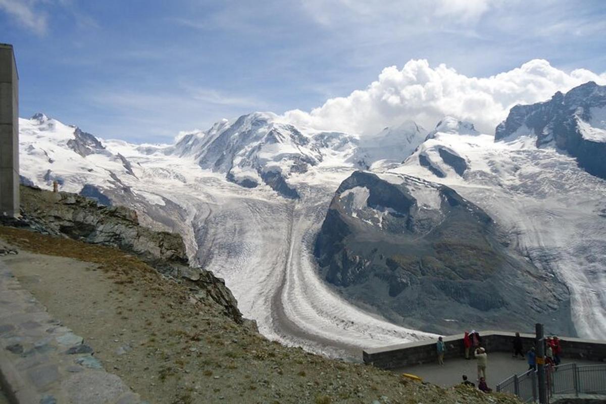 a view of a snow covered mountain with people standing on top