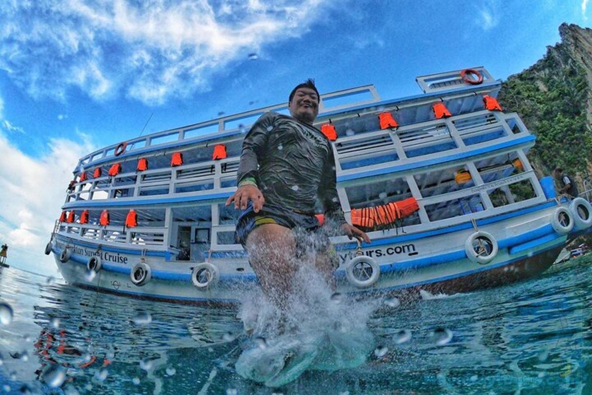a man standing in the water in front of a bus