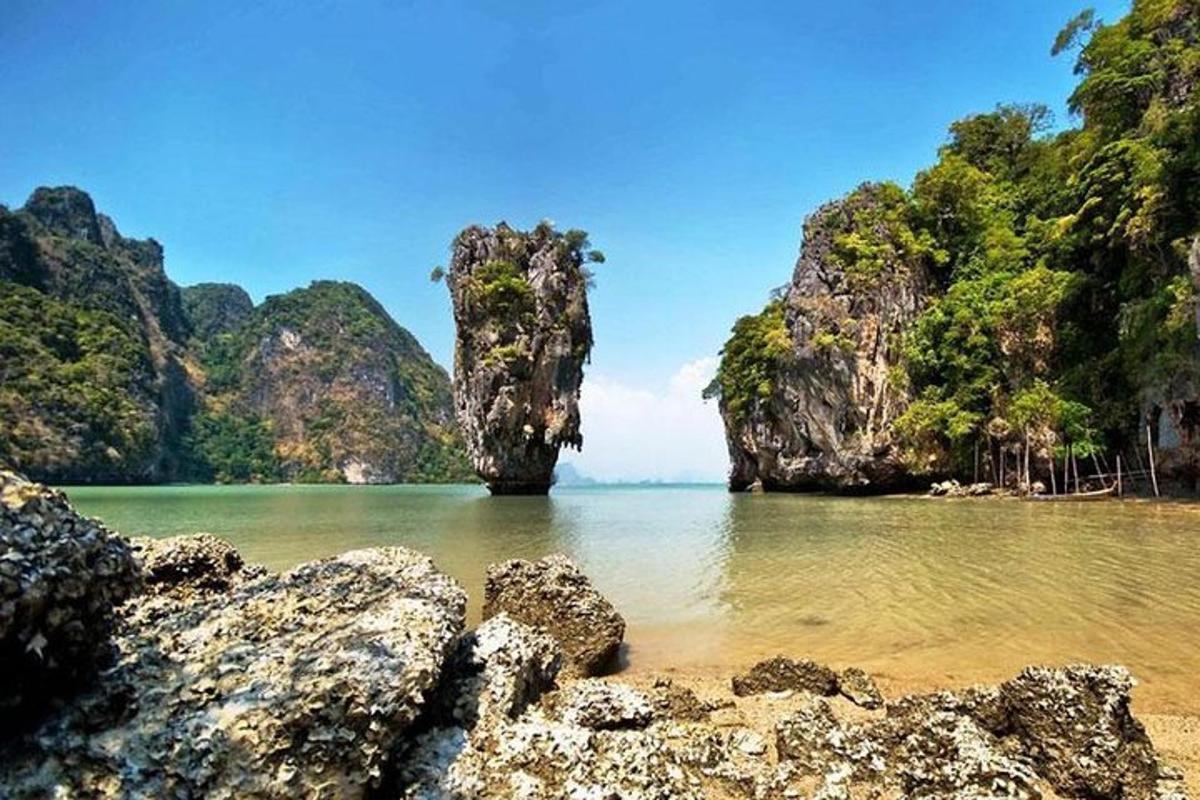 uma praia com pedras e uma caverna na água